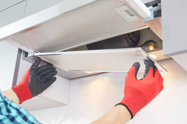 mãos masculinas de um eletricista solucionam um capô de alcance. reparo da coifa da panela. trabalhador montagem de capô de casa em móveis de cozinha. - exhaust fan - fotografias e filmes do acervo