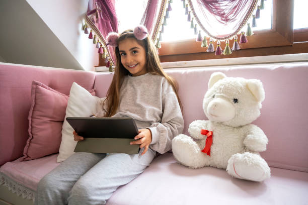 istock Littel girl using digital tablet at home 1296150884