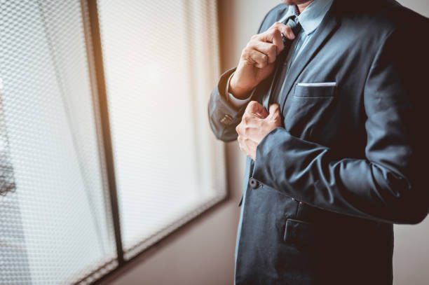 The management is wearing a suit and tie before entering the meeting room.Business and working concept. The management is wearing a suit and tie before entering the meeting room.Business and working concept. necktie fashion adjusting suit stock pictures, royalty-free photos & images