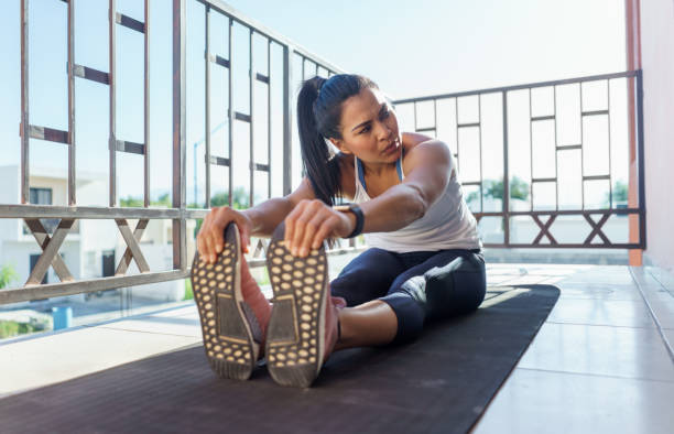 istock Young woman exercising sitting at mat outdoors at balcony 1296152294