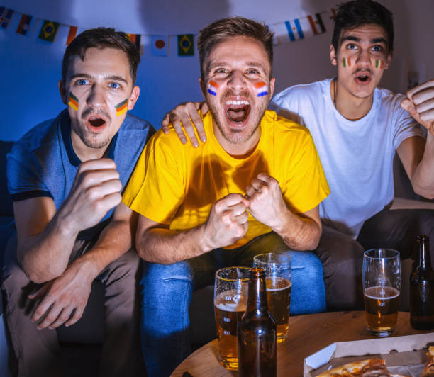 istock Sport fans watching a game together 1296153340