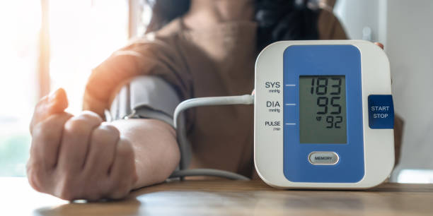 nadciśnienie tętnicze lub wysokie ciśnienie krwi u pacjenta z monitorowaniem ciśnienia krwi, pomiar na cyfrowym sfigmomanometrze do samodzielnej kontroli zdrowia w domu - ciśnienie zdjęcia i obrazy z banku zdjęć