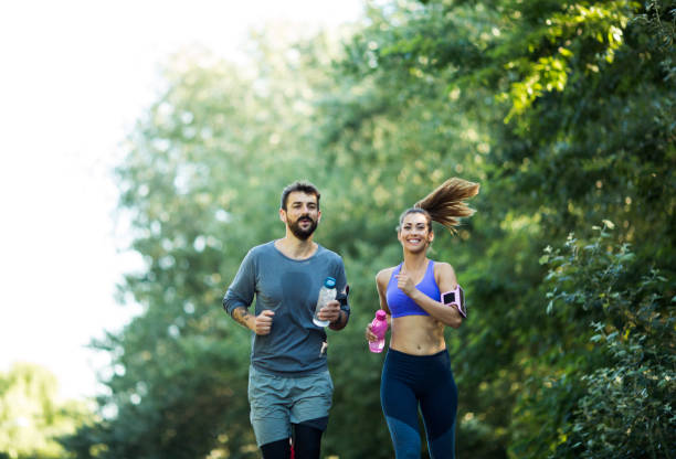 istock Couple jogging, carrying water bottles. 1296157197