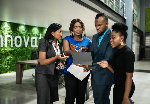 istock Diverse businesspeople discussing work together in an office lob 1296157941
