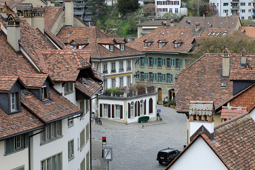 Bern, Switzerland - April 16, 2018: The houses of the old town are covered with ceramic tiles. There are paved streets in between the houses. The city of Bern is one of the countless great places in Switzerland and is the political center of this country. Numerous museums, a wide cultural offer, a variety of tourist attractions makes it a travel destination for tourists from all over the world.