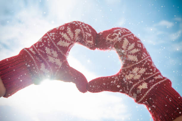 le mani delle donne nei guanti invernali rendono la forma del segno del cuore - glove winter wool touching foto e immagini stock