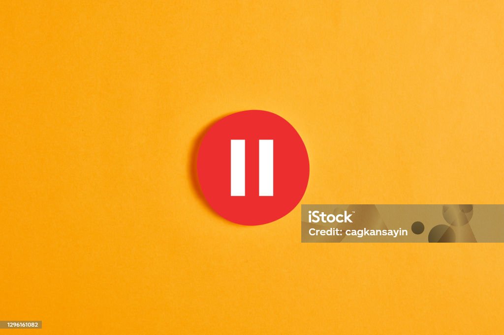 Red round circle with a pause button or icon Red round circle with a pause button or icon against yellow background. Resting Stock Photo