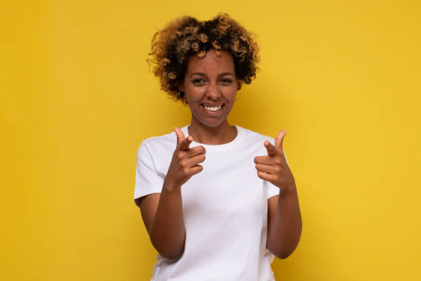 istock Happy young african woman looking camera while pointing to you. 1296161789