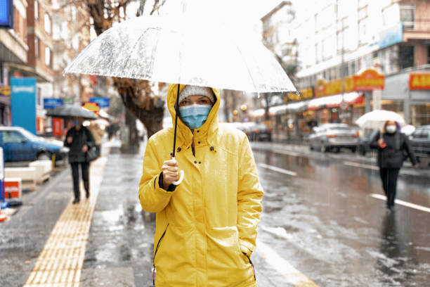 雨の日に傘を持つ女性 - umbrella women storm yellow ストックフォトと画像