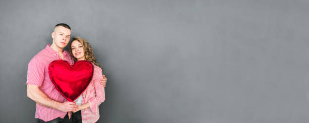 istock Young couple hugs and holds a red balloon 1296163379