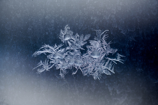 Beautiful frosty pattern with crystals on the cold glass stock photo
