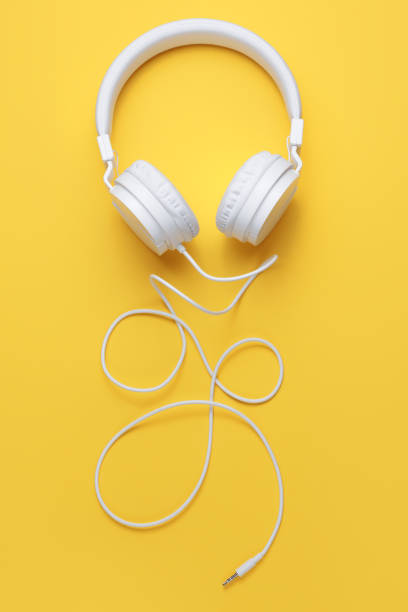 istock Stylish white headphone on yellow background. Music concept. 1296163827