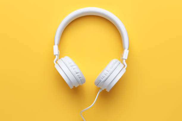 istock Modern white headphone on yellow background. Music concept. 1296163835
