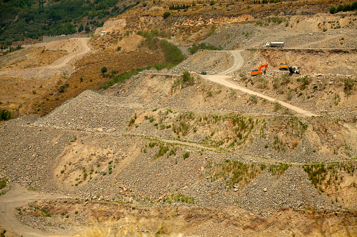 Backlight on the eroded moraines, jagged by runoff water with a few pinaceae which decorate these gray sediments.\nPhoto taken on the website of the “Salle de Bal des demoiselles coiffées”