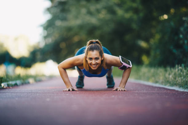 istock Young woman doing planks on treadmill on sunny day. 1296168238