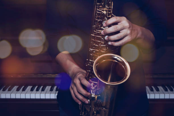 istock musician plays alto saxophone over piano background 1296169751
