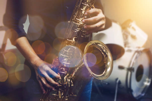 istock A man plays tenor saxophone on stage with light bokeh effected 1296169754