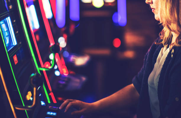 istock Woman Playing Casino Slot Machine Game 1296170417