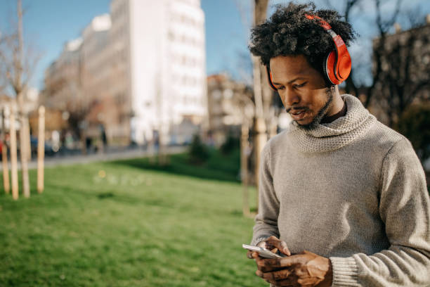 istock Young man walking and listening music 1296170701