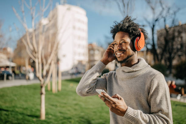 istock Young man walking and listening music 1296170738