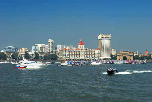 Ever crowded, busy sea front of Mumbai full of luxury yatches and colorful cruise vessels and launches on the backdrop of Mumbai's iconic landmark Gateway of India. Copy space.