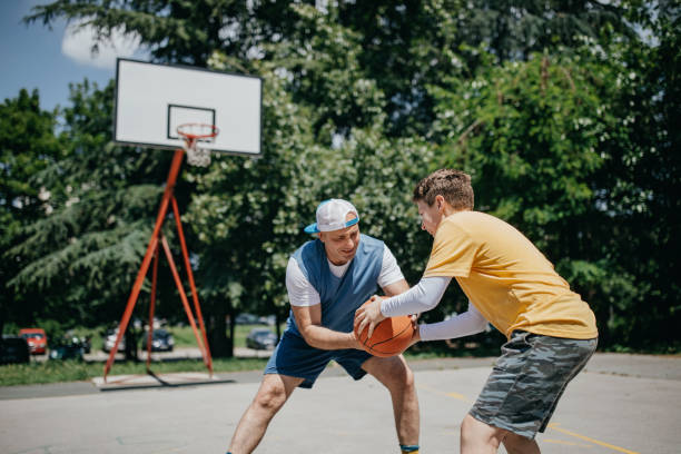 istock Young boy plays basketball with his father 1296172146