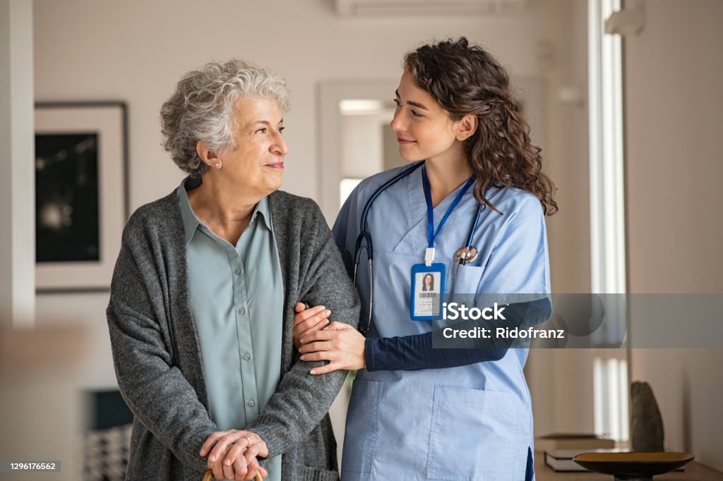 Betreuer helfen Seniorin zu Hause - Lizenzfrei Heilbehandlung Stock-Foto