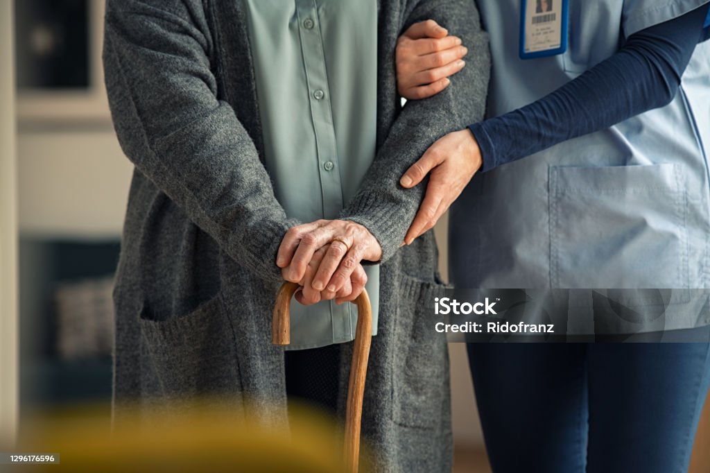 Krankenschwester hilft Senior mit Fußstock - Lizenzfrei Altersheim Stock-Foto