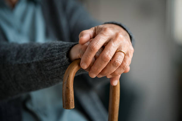 istock Old woman hands holding walking stick 1296176619