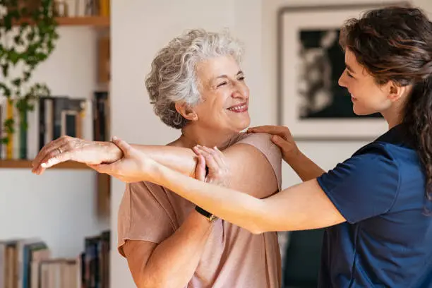 Photo of Senior woman with trainer exercising at home