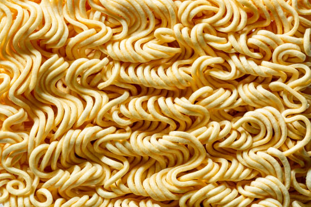 istock Macro instant raw noodle. Close-up uncooked ramen texture. Food background, top view 1296178550