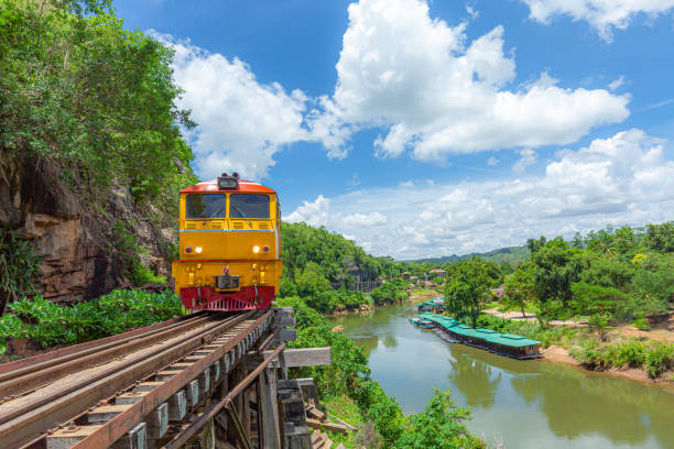 treno, ferrovia storica della seconda guerra mondiale, conosciuta come la ferrovia della morte con molti turisti sul treno che scattano foto di splendide viste sul fiume kwai noi, provincia di kanchanaburi, locomotiva, treno a vapore, thailandia. - kanchanaburi province train thailand diesel foto e immagini stock