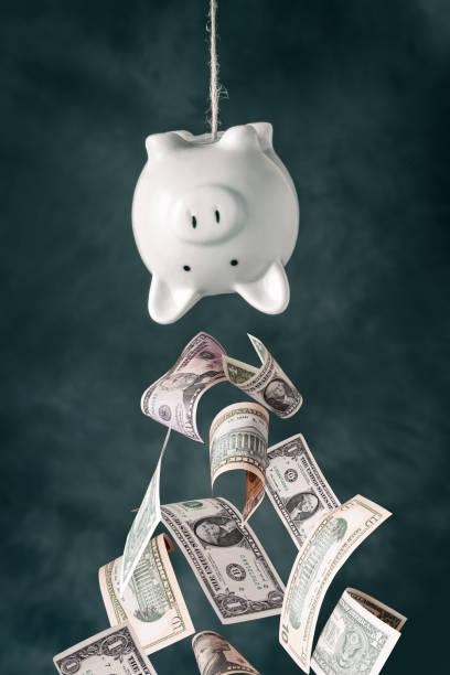 istock Dollars falling out of piggy bank 1296179949
