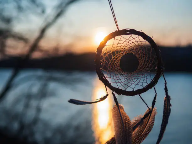 Wicker handmade dream catcher made of willow branches at sunset