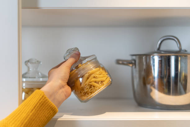 istock Woman pulls out a glass jar from the shelf 1296181135