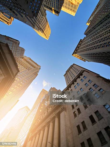 Buildings Of Wall Street Towering Overhead Against A Blue Sky Background In The Historic Financial District Of New York City Stock Photo - Download Image Now