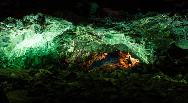vue panoramique du tube vert de lave de caverne illuminé dans les îles canaries - lanzarote canary islands volcano green photos et images de collection
