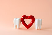 teeth and red heart on a pastel background. Oral care and St. Valentine's day concept.