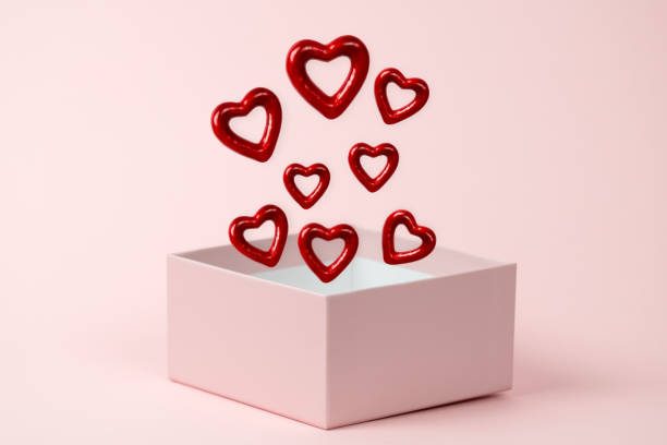 istock Gift box open with  red hearts floating on a  pink background. 1296185260