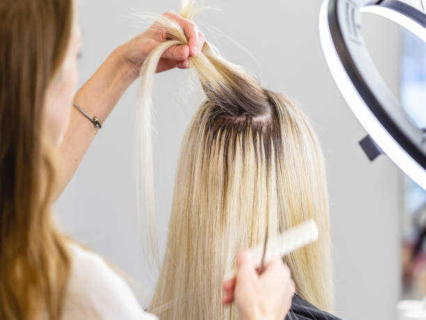istock Blonde hair extensions procedure in beauty salon 1296185320