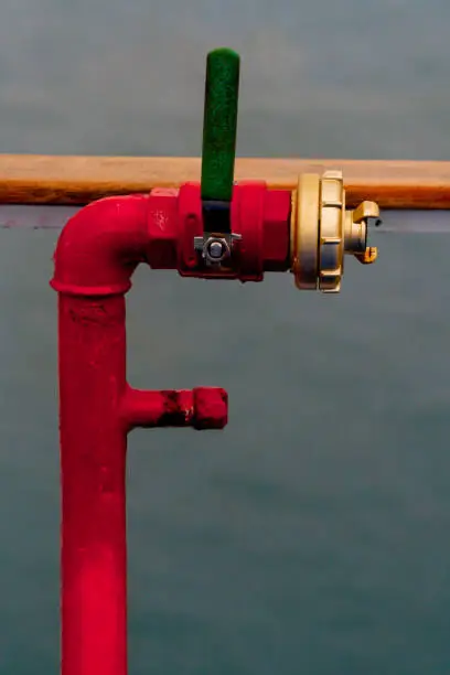Red fire hydrant pipe with handle. Close up.
