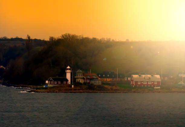 istock Classic lighthouse by a small port on an island in the sunset. 1296186749
