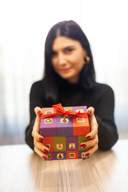 istock Young woman giving a gift 1296189492