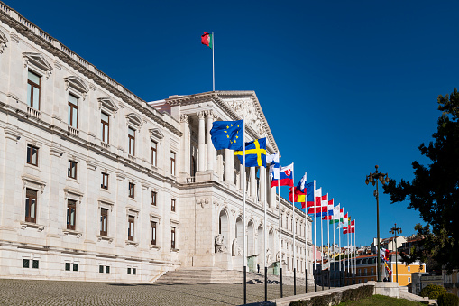 Lisbon, Portugal - January 10, 2021: The facade of the Assembleia da Republica (Portuguese Parliament), with the European union countries flags to sign the Portuguese presidency of Council of the EU