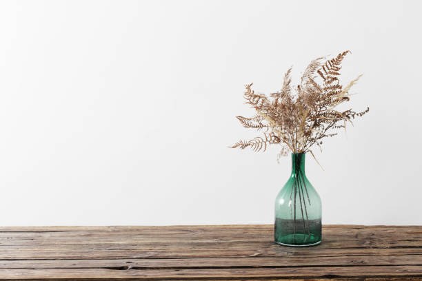 istock dried flowers in vase on wooden table on white background 1296190858
