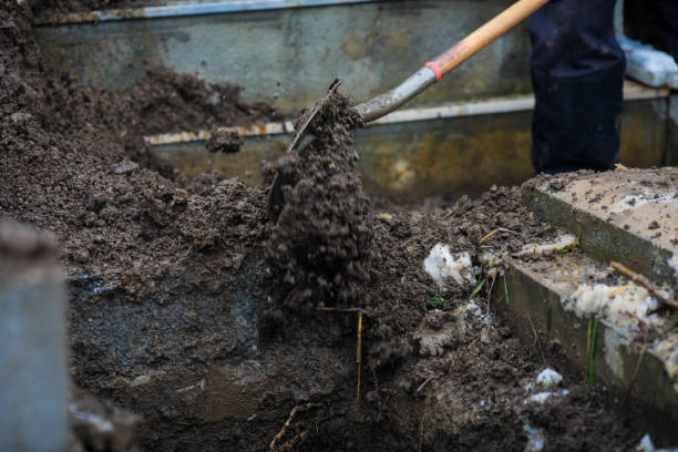 Details of a gravedigger covering a tomb with dirt with a shovel during a burial ceremony on a cold and snowy winter day. Details of a gravedigger covering a tomb with dirt with a shovel during a burial ceremony on a cold and snowy winter day. grave digger stock pictures, royalty-free photos & images