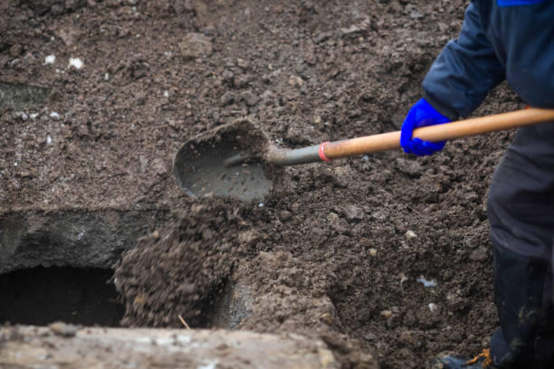 Details of a gravedigger covering a tomb with dirt with a shovel during a burial ceremony on a cold and snowy winter day. Details of a gravedigger covering a tomb with dirt with a shovel during a burial ceremony on a cold and snowy winter day. grave digger stock pictures, royalty-free photos & images