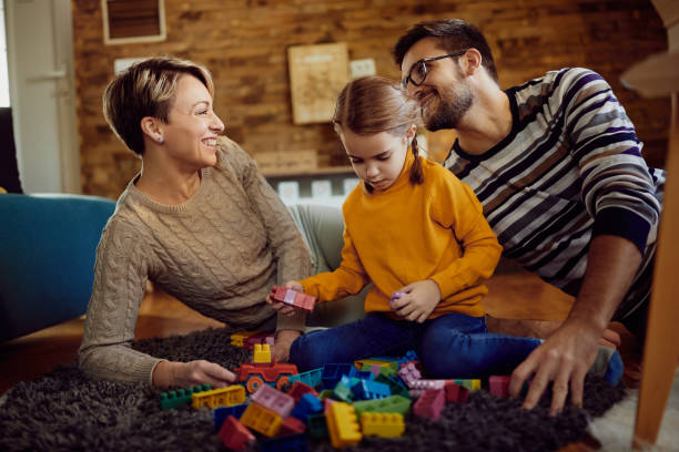 istock Happy family having fun while playing with toy block at home. 1296191869
