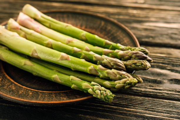 istock Fresh green asparagus on wooden background 1296192498