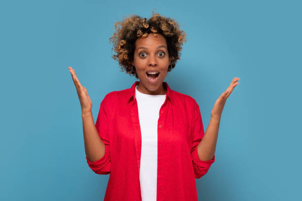 istock Young african american woman smiling posing on blue background 1296193642